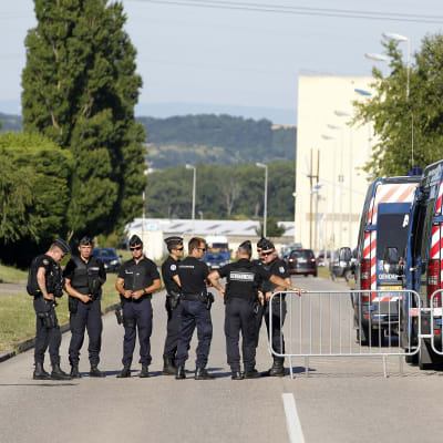 Poliser utanför gasfabriken nära franska Lyon där en man halshöggs 26.6.2015.