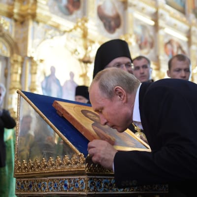 Vladimir Putin kissing an icon