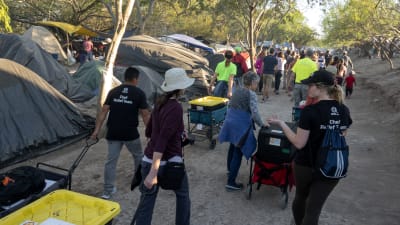 Frivilliga delar ut mat i migrantlägret i Matamoros i Mexico vid gränsen mot USA.