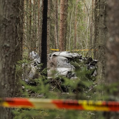 Hawk-koneen jäänteitä metsässä puiden seassa. Etualalla sulkunauha.