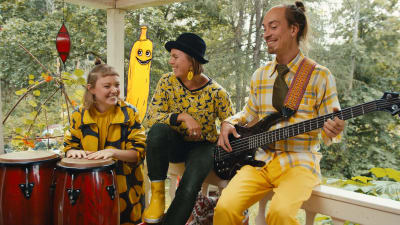 Tre musiker sitter bredvid varandra och ler