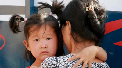 Kirgizisisk flyktingmamma med sin dotter vid gränsen mellan Tadzjikistan och Kirgizistan.