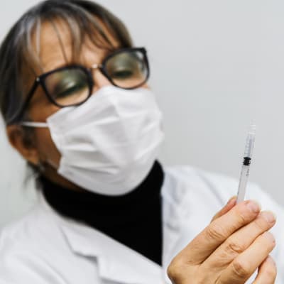 Sote-henkilöstölle annettiin Pfizerin koronavirusrokotteita Helsingissä 4. tammikuuta 2021. Sairaanhoitaja Paula valmisteli rokotteita takahuoneessa, eli sekoitti rokotetta ja keittosuolaliuosta valmiiksi ruiskuihin.