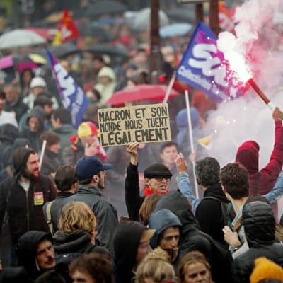 Tusentals demonstrerade i Paris mot arbetsreformen. "Macron och hans värld dödar oss lagligt," står det på skylten.