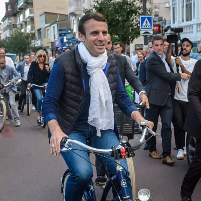 President Emmanuel Macron och hans hustru Brigitte Trogneux (till vänster bakom Macron) på cykeltur på lördagen.