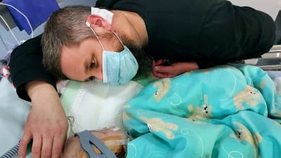 Pappa Vesa Luoma stryker Jaakko-bebisens huvud på intensivvårdsavdelningen.