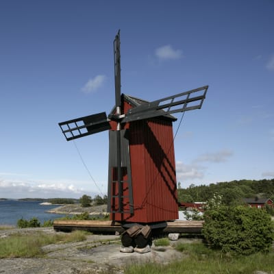 Vy över ön Gullkrona. Man ser väderkvarnen och segelbåtar i besökshamnen.