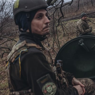 En ukrainsk stridsvagn med två man ur manskapet tar en paus i en skogsdunge nära Bachmut i Donetsk.