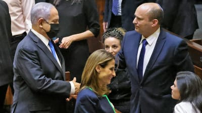 avgående premiärministern Benjamin Netanyahu skakar hand med blivande premiärminister Naftali Bennett 13.6.2021