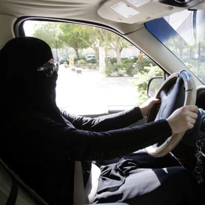 En beslöjad saudisk kvinna sitter bakom ratten i Riyadh i oktober 2013. 