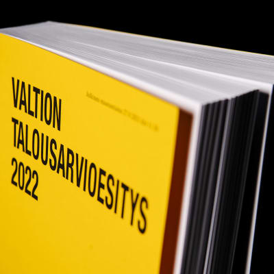 Keltainen Valtion talousarvioesitys 2022 -kirja mustalla taustalla.