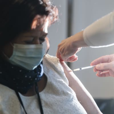 En person får coronavaccinet i Helsingfors i början av januari 2021.