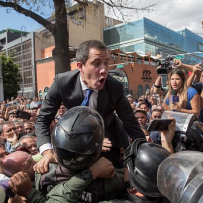 Den venezuelanska oppositionsledaren Juan Guaidó pressar sig förbi säkerhetsstyrkor den 7 januari 2020 för att kunna ta sig till parlamentet.