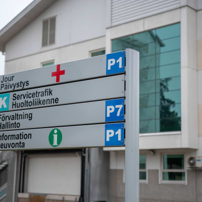Ekenäs sjukhus sett från baksidan med en skylt i förgrunden