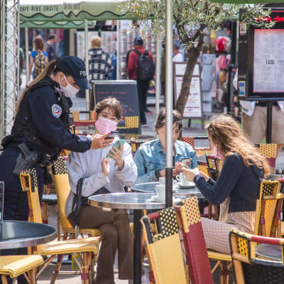 Poliisi tarkasti asiakkaiden koronapasseja pariisilaiskahvilassa maanantaina.
