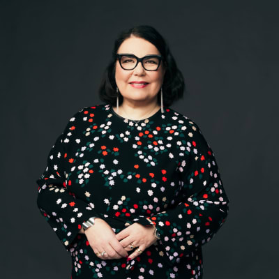 På bilden Yles verkställande direktör Merja Ylä-Anttila. Hon är klädd i en småblommig blus och ler mot kameran.