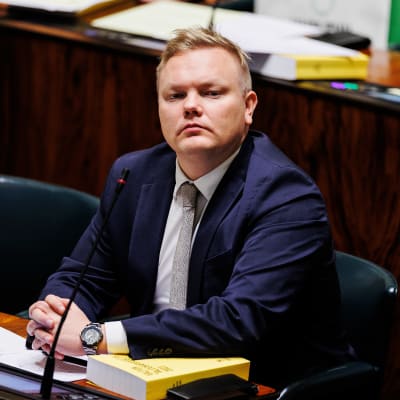 Antti Kurvinen sittande på sin plats i riksdagens plenisal. 