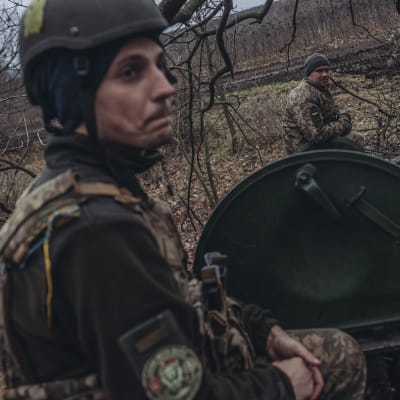 En ukrainsk stridsvagn med två man ur manskapet tar en paus i en skogsdunge nära Bachmut i Donetsk.