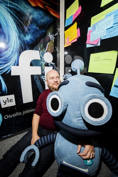  Jarkko Ryynänen poseeraa Voitto-uutisrobottia esittävän pehmolelun kanssa.