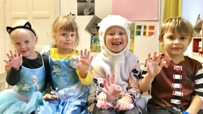 Fyra glada dagisbarn i maskeradkläder.