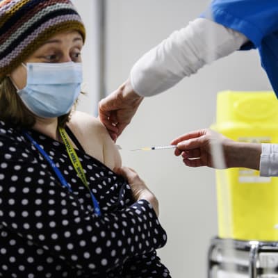En kvinna får coronavaccin i Helsingfors 4.1.2021.