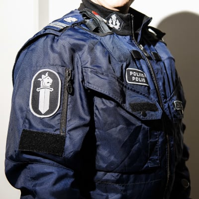 Yksityiskohta poliisin sinisessä virkapuvussa.