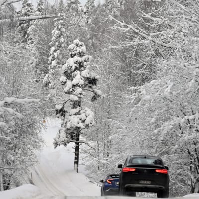 Autoja lumisessa maisemassa.