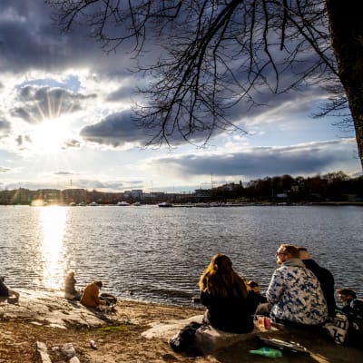 Ihmisiä Siltasaaressa nauttimassa auringosta.