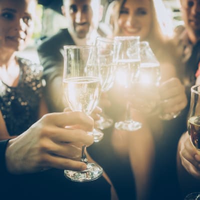 Leende människor skålar i champagne