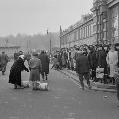 Ihmisiä jonottamassa silakkatynnyreitä Helsingin satamassa Vanhan kauppahallin luona vuonna 1941.