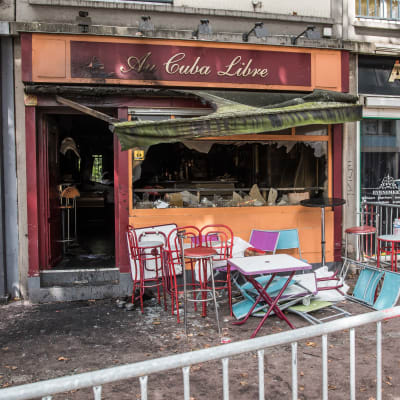 Den brandförstörda baren Au Cuba Libre i Rouen, Frankrike: krossade fönster, sotig utsida och fällda stolar.