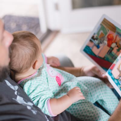 Pappa och bebis läser bok