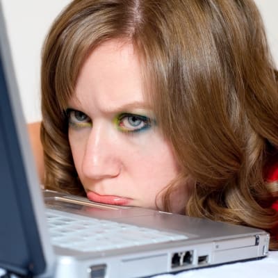 Kvinna lutar hakan på dator och ser trumpen ut.
