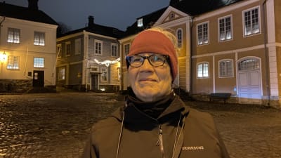 Barbro står på rådhustorget i Borgå med julljus i bakgrunden.