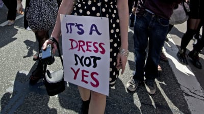 Kvinna med skylten "It's a dress, not a yes".