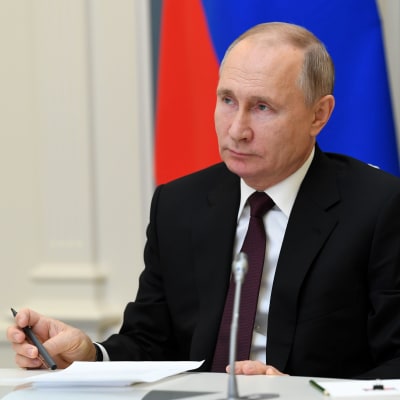 Venäjän presidentti Vladimir Putin kynä kädessään