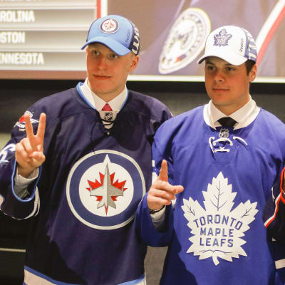 Tre unga ishockeylöften poserar i sina respektive klubbtröjor.