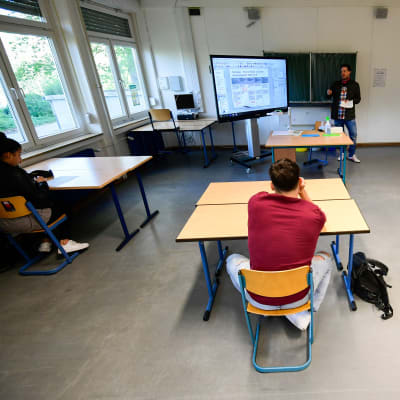 Tre elever och deras lärare med gott om skyddsutrymme, i skola i Dortmund. 
