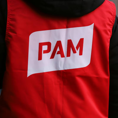En person som har ryggen mot kameran som bär en röd väst med servicefacket Pams logo.