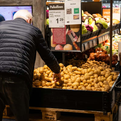 yleiskuva - ruokakaupan hevi-osasto. Mies poimii perunoita laarista.