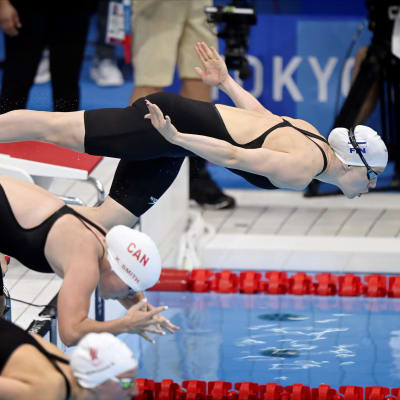 Ida Hulkko ilmassa hyppäämässä altaaseen 100 metrin rintauinnin alkuerässä Tokion olympialaisissa.