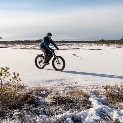 En terrängcyklist som cyklar på skaren vintertid.