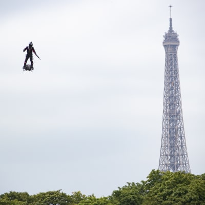 En man flyger på en flygbräda bredvid Eiffeltornet.
