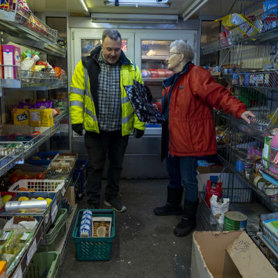 Pertti Rislakeus ja asiakas Salli Latvala keskustelevat myymäläauton käytävällä.