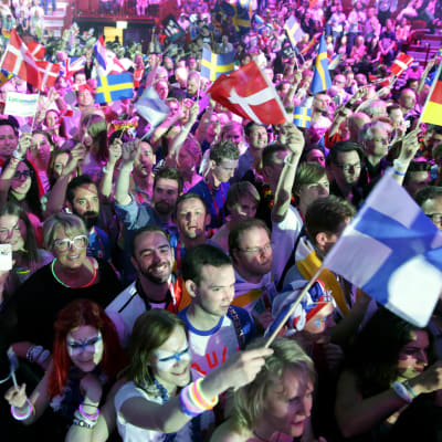 Eri maiden euroviisufaneja kasvomaaleissa ja lippuja liehuttamassa yleisössä.