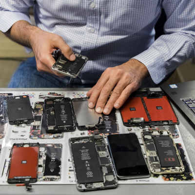 Verkstad med bord fylld av smarttelefoner som repareras.