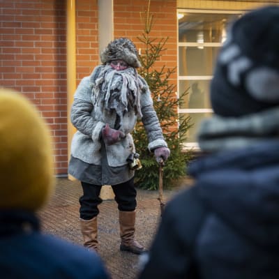 Harmaa pukki esiintyy lapsille koulun pihalla. 
