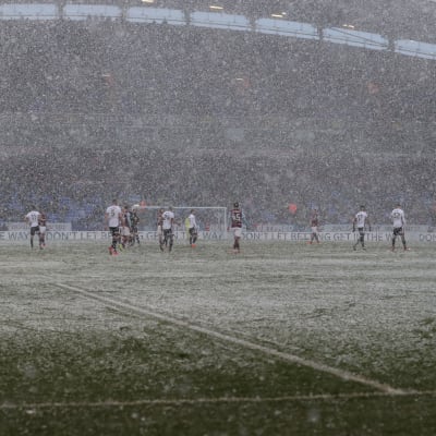 Det snöar under en fotbollsmatch.