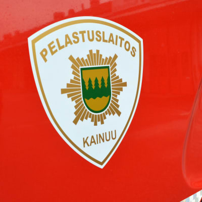 Kainuun pelastuslaitoksen logo punaisen auton kyljessä.