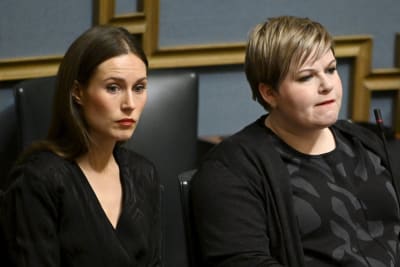 Sanna Marin och Annika Saarikko med allvarliga miner i riksdagen.